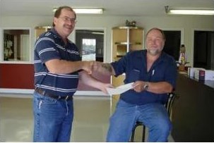 Two people shaking hands over a document